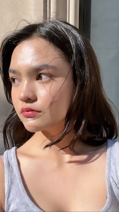 a close up of a person wearing a tank top and looking off to the side