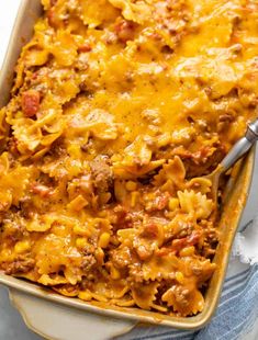 a casserole dish with meat, cheese and pasta in it on a table