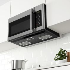 the microwave is built into the wall above the potted plant on the counter top