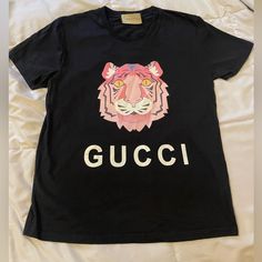 Black T-Shirt With Gucci Tiger Design, Shirt Is In Amazing Condition With Small Mark On Tiger’s Right Upper Ear (Due To Ironing, Please See Picture) . Upper Tag Is Unattached On Right Side(Shown On Video). Gucci Tiger, Gucci Top, Gucci T Shirt, Tiger Design, Gucci Black, Black T Shirt, Right Side, Black Tshirt, Colorful Shirts