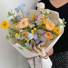 a woman holding a bouquet of flowers in her hands