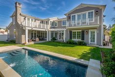 a large house with a swimming pool in the front yard and an attached deck area