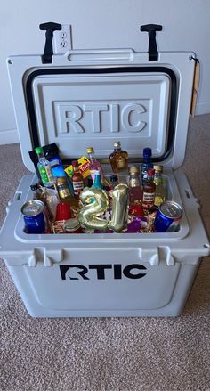 a cooler filled with lots of different types of drinks and condiments sitting on the floor