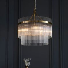 a chandelier hanging from the ceiling in a room with dark walls and white flowers