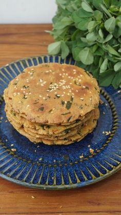 a stack of pancakes sitting on top of a blue plate next to a potted plant