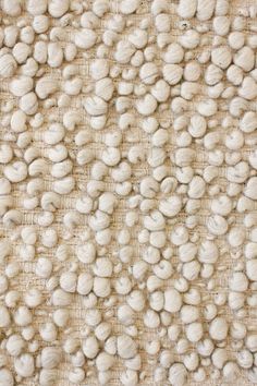 a close up view of some white rocks on a cloth textured wallpaper pattern