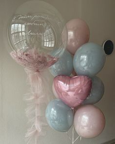 some balloons are hanging on the wall and one balloon has a heart shaped balloon attached to it