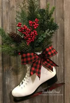 a pair of ice skates with red berries and pine cones tied to the top