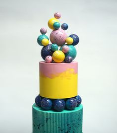 there is a multi - colored cake with balls on top