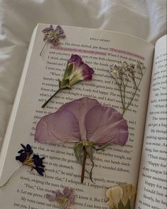 an open book with flowers on it