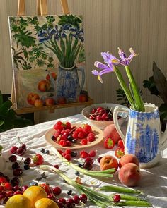 an arrangement of fruit and flowers on a table