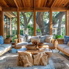 a living room filled with lots of furniture under a wooden ceiling covered in large windows