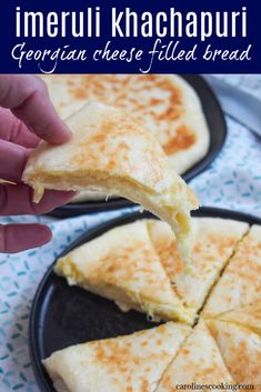 someone is dipping cheese on top of cheesy bread in a black plate with blue and white napkins