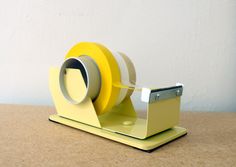 a yellow tape dispenser sitting on top of a table