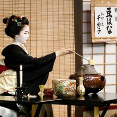 a woman sitting at a table holding a stick