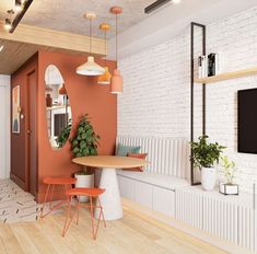 an orange and white living room with wood floors, brick wall, and round table