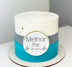 a white and blue cake with the name melhora pai on it's side