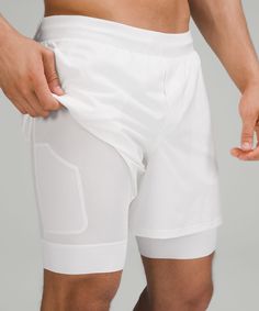 a close up of a person wearing white shorts and holding his hand in his pocket