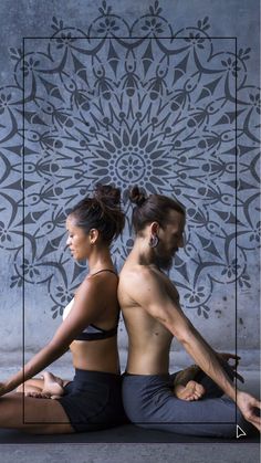 two people are sitting on the ground doing yoga exercises in front of a patterned wall