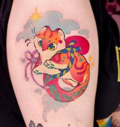 a colorful tattoo on the arm of a person with a cat and butterfly design on it