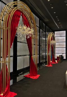 a red and gold wedding ceremony setup with chandeliers