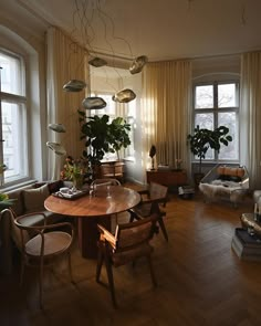 a living room filled with lots of furniture and plants on top of windowsills