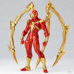 the action figure is wearing gold armor and holding two large metal swords in one hand