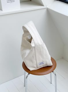 a white bag sitting on top of a wooden chair