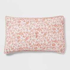 an orange and white floral pillow on a white background