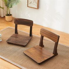 two wooden chairs sitting on top of a rug