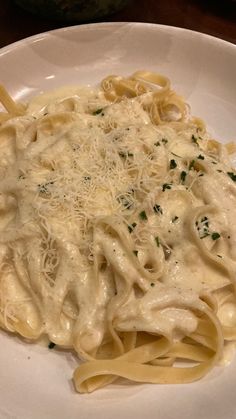 a white plate topped with pasta covered in sauce