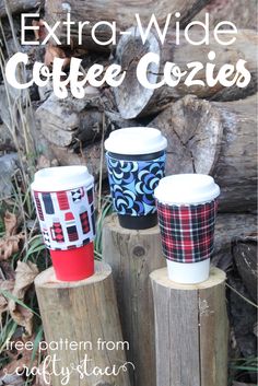 three coffee cups sitting on top of wooden logs with the words extra wide coffee cozies