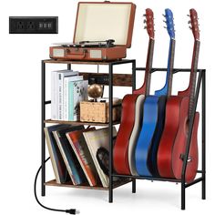 the guitar stand is holding several guitars and other musical equipment, including a record player