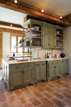 an image of a kitchen setting with green cabinets and plates on the counter top,