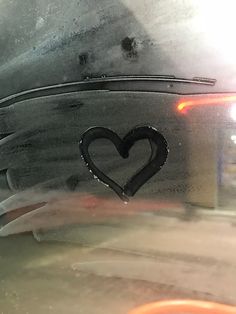 a heart is drawn on the hood of a car