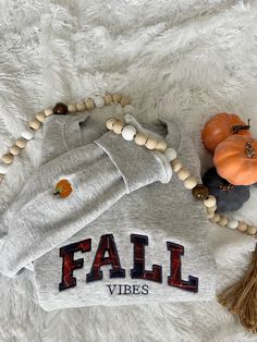 a sweater with the word fall vibes on it next to some pumpkins