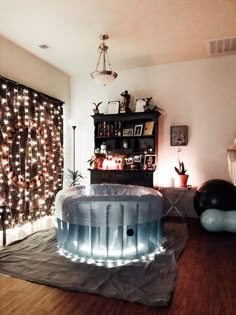 a living room filled with furniture and christmas lights on the wall behind it is an inflatable pool