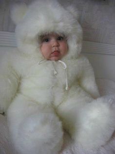 a baby is dressed in a white teddy bear costume