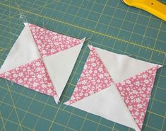 two pieces of fabric sitting on top of a cutting board