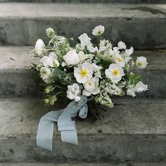 a bouquet of white flowers sitting on some steps