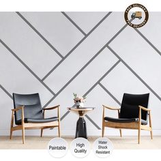 two chairs sitting next to each other in front of a wall with geometric designs on it