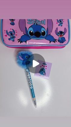 a pink pencil case with blue stuff on it and a small toothbrush in front of it