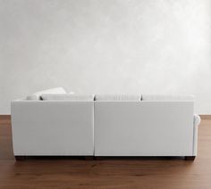 a white couch sitting on top of a wooden floor