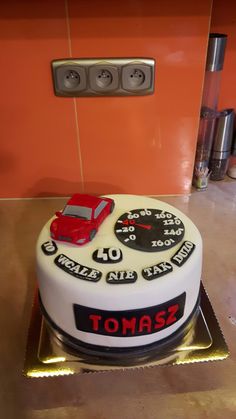 a white cake with red car and speedometers on it