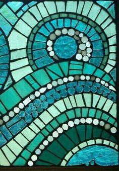 a close up of a stained glass window with blue and green designs on the side