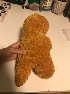 a person is holding a teddy bear made out of bread