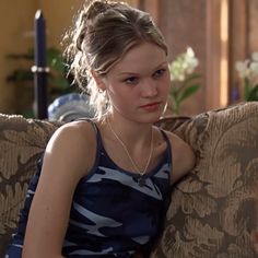 a young woman sitting on top of a couch