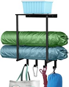 three bags and two umbrellas are hanging from a rack on a white background with a blue tote bag in the foreground