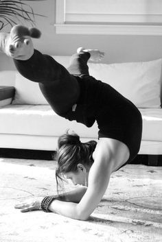 a woman is doing a handstand on the floor