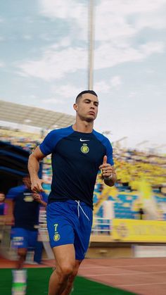 a man running on a track in front of a stadium filled with people and fans